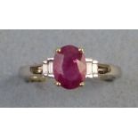 A ruby and diamond ring, comprising central oval ruby (1.14ct) flanked to either side by two