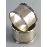 A pair of Victorian napkin rings, each of circular form with raised reeded rim, chased centre and