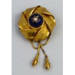 A Victorian brooch, of woven chased ribbon style, the enamelled cabochon centre with a diamond in