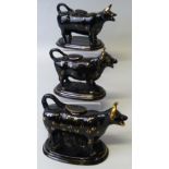 Three 19th century Staffordshire black glazed cow creamers, each with tail loop handle and lid and