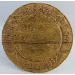 An oak bread board, of circular form the border carved with shields, acanthus leaves and the