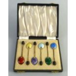 A set of six silver gilt coffee spoons, each with a black bean terminal and different colour