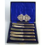 A set of six Victorian tea knives, with silver handles, cased, London 1897 and a cast white metal