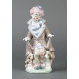 A Lladro figure of a clown with dog and puppies beneath a coat, 5901, boxed 10"This lot is in good