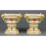 A pair of 19th Century Derby urn shaped dishes with mask handles and floral decoration on claw