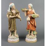 A pair of Royal Dux figures of male and female water carriers on raised bases 14 1/2"The female