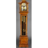 A chiming longcase clock with 7" arched gilt dial and silvered chapter ring contained in an oak case