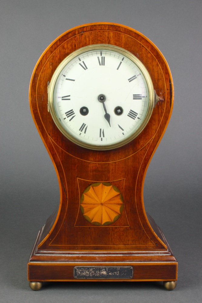 An 8 day striking mantel clock with enamelled dial and Roman numerals contained in an inlaid
