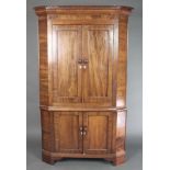 A 19th Century mahogany corner cabinet with moulded cornice, fitted cupboards enclosed by panelled