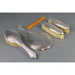 An engine turned silver backed 5 piece brush set with chased monogram Birmingham 1926