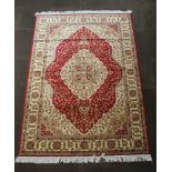 A red and white ground Belgian cotton rug with central medallion 90" x 63"