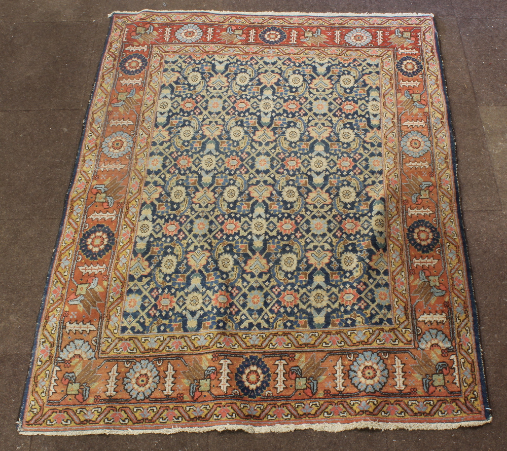 A Persian Isfahan rug with blue ground and floral pattern 71" x 55"