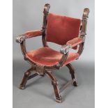 An Italianate style carved oak open frame armchair upholstered in burnt orange draylon