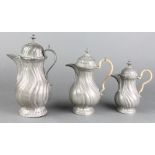 2 baluster shaped pewter hot water jugs of swirl form, the bases marked Engl Block Finn 7" and 6 1/