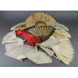 An Edwardian red silk parasol with a carved bone handle, 11 Edwardian and later fans