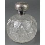 An Edwardian silver mounted spherical cut glass toilet bottle with hammer patterned lid 5"