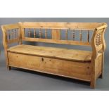 A 19th Century Continental stripped and polished pine settle, the raised back with spindle