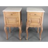 A pair of 19th Century French oak bedside cabinets with white veined marble tops fitted a drawer,