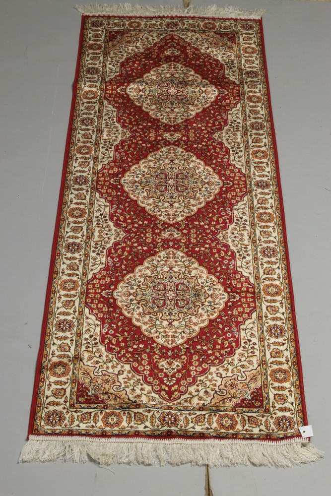 A red ground Persian style Belgian cotton runner with 3 medallions to the centre 82" x 27"