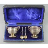 A cased pair of Edwardian silver salts in the form of 2 handled cups with spoons, Chester 1911, 68