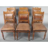 A set of 6 Edwardian carved oak dining chairs, the seats and backs upholstered in brown leather,