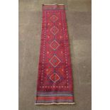 A red and blue ground Meshwani runner with 5 octagons to the centre within a multi-row border 104" x