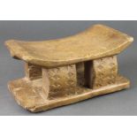 An "Ashanti" carved head rest 4" x 9" x 5" together with a carved and pierced hardwood spear, the