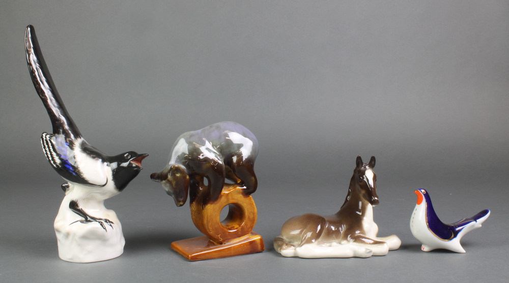 A Russian figure of a bear standing on a wheel 5 1/2", 2 Russian figures of birds and a reclining