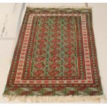 A green ground Bokhara rug with 30 octagons to the centre within a multi row border 24" x 49"