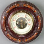 An aneroid barometer with enamelled dial contained in a carved mahogany case 7"