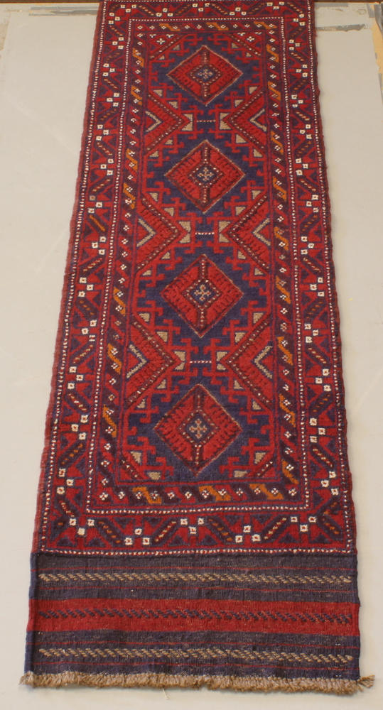 A Meshwani red and blue ground runner with 4 octagons to the centre 100" x 25"