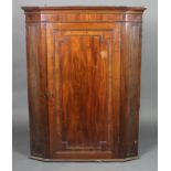 A Georgian mahogany hanging corner cabinet with moulded cornice, the interior fitted shelves