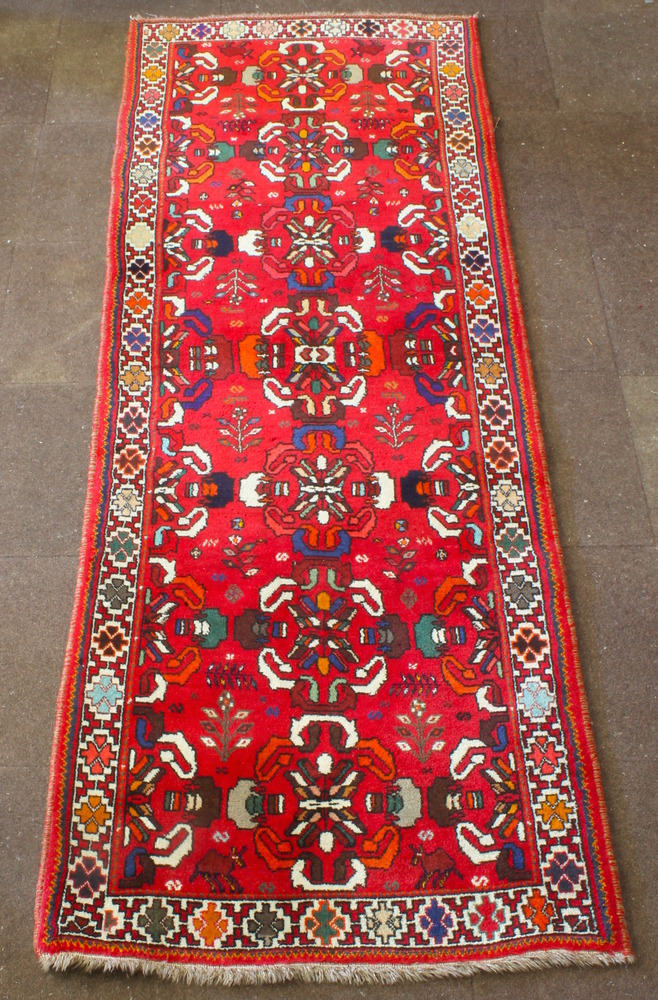 A Persian Qashqai runner with red ground and 7 medallions to the centre 112" x 42"