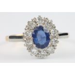 An 18ct yellow gold sapphire and diamond cluster ring, the centre stone approx. 0.75ct surrounded by