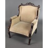 An Edwardian mahogany show frame armchair upholstered in mushroom coloured material, raised on