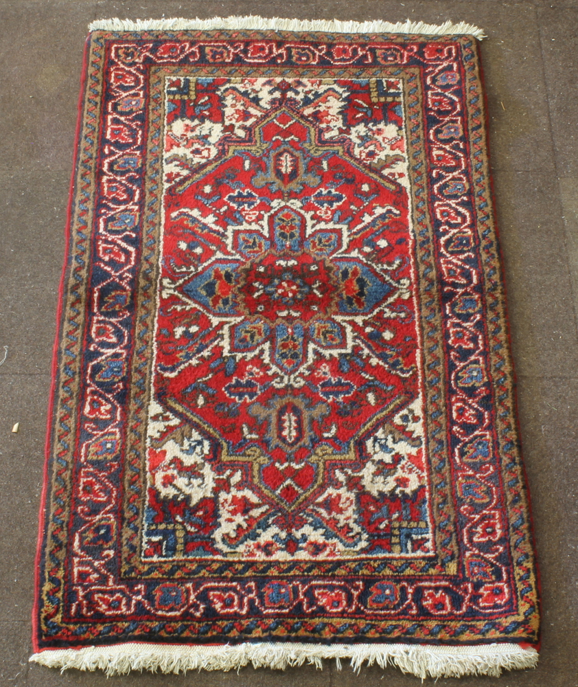 A Persian Heriz red ground rug with central medallion 59" x 34"