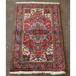 A Persian Heriz red ground rug with central medallion 59" x 34"