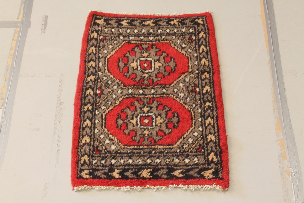 A red and white ground Uzbek "Bokhara" rug with 2 octagons to the centre 38" x 26"