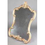 A shaped plate wall mirror contained in a gilt carved wood and plaster frame 35"h x 24"wThere is