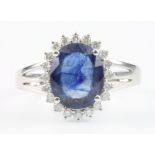 A 14ct white gold sapphire and diamond cluster ring, the centre stone approx. 3ct surrounded by 20
