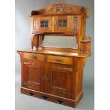 An Arts & Crafts oak sideboard with pierced raised back fitted a cupboard enclosed by lead glazed