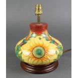 A late 20th Century Moorcroft squat shaped baluster table lamp, the red ground decorated with