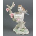 A Lladro figure of a bird sitting on its nest in a flowering tree 6"