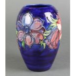 A late 20th Century Moorcroft oviform vase, the blue ground decorated with anemone with impressed