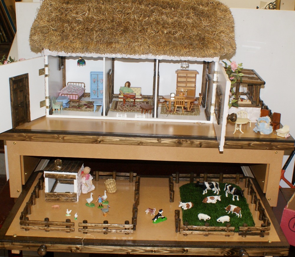 Large dolls house on play stand with lower drawer which pulls out to reveal farm