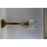 A LATE VICTORIAN BRASS TABLE OIL LAMP, the polygonal clear glass fount raised on a reeded column and