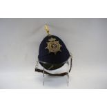 A BRITISH OLD STYLE BLUE CLOTH HELMET with ''67'' helmet plate, brass spike & chin strap.  (possibly