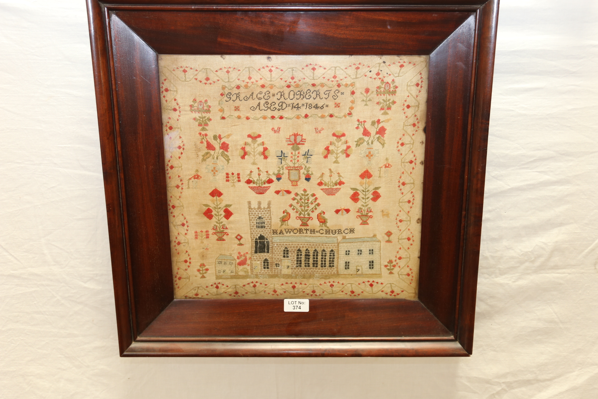 A 19TH CENTURY NEEDLEWORK SAMPLER embroidered with Haworth Church, by GRACE ROBERTS, aged 14,