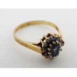 A 18ct gold ring set with central topaz bordered by diamonds in a cluster setting  CONDITION: Please