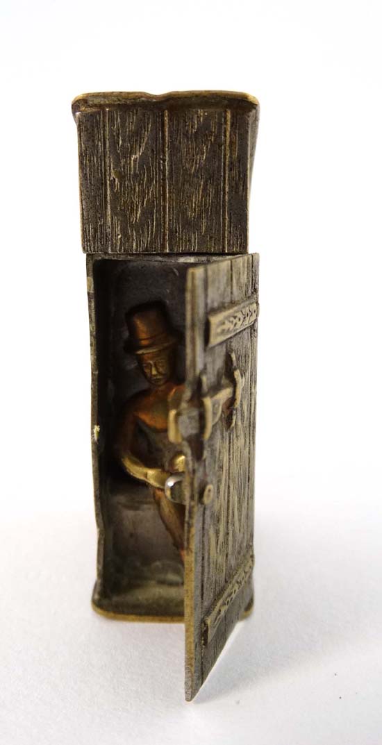 A c.1900 novelty vesta in the form of a wooden privy , the door hinging to reveal a man sat